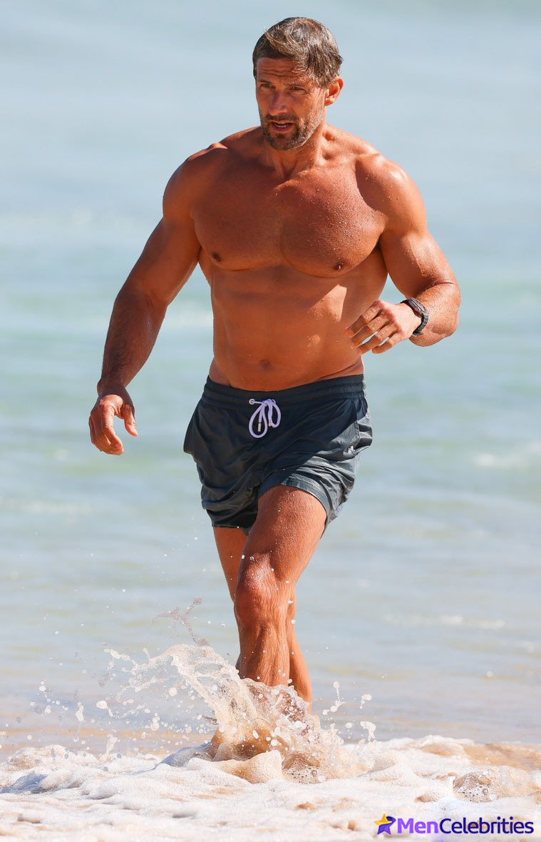 Tim Robards shows off his muscular torso on the beach